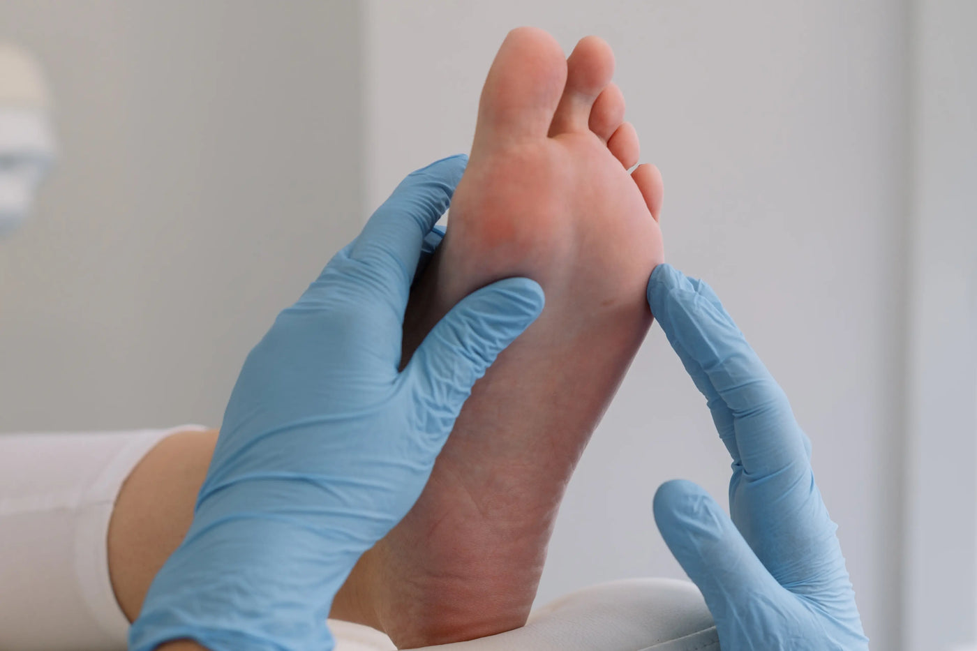 podologue qui regarde le pied d'une patiente avec une verrue