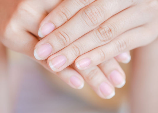 Gros plan sur des ongles de mains roses et blancs en bonne santé