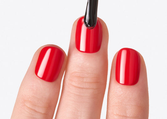Gros plan sur des ongles dont le vernis rouge avec une longue tenue